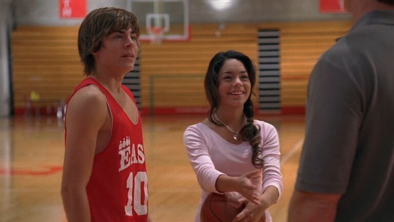 Gabriella die naast Troy met een basketbal in haar handen staat.