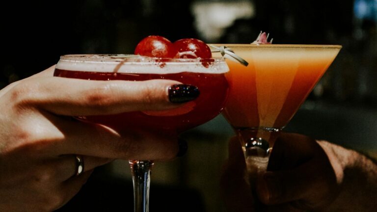 Twee vrouwen proosten met een cocktail.