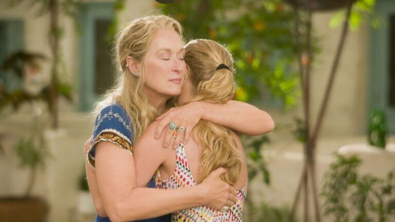 Moeder en dochter uit Mamma Mia! geven elkaar een knuffel.