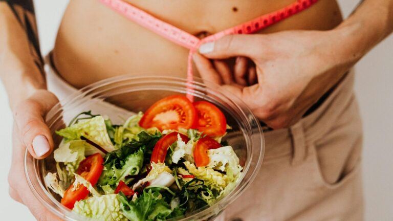 Een vrouw die een salade vast heeft.