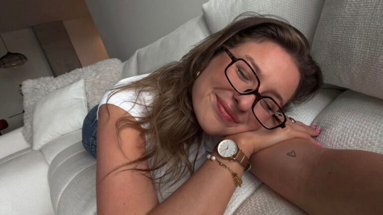 Vrouw met een bril die op de bank ligt.