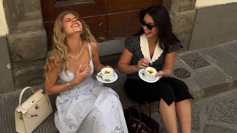 Twee vrouwen die lachen en koffiedrinken.