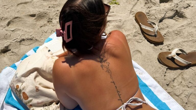 Meisje ligt te zonnen op het strand.