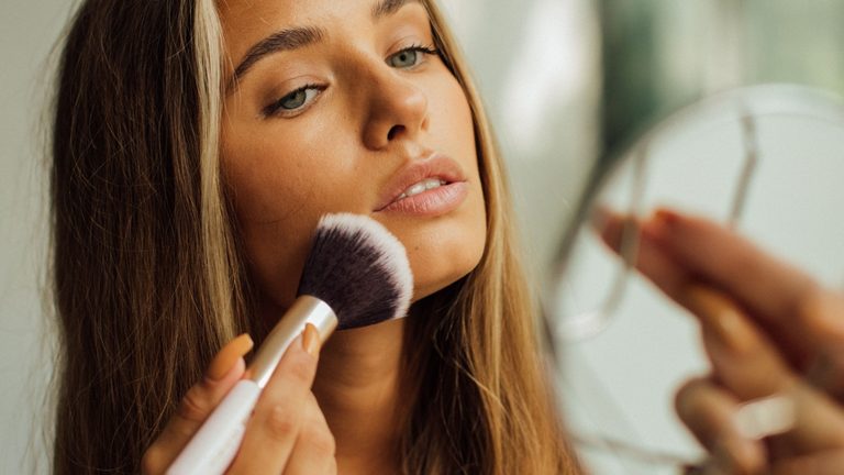 Vrouw brengt bronzer aan.