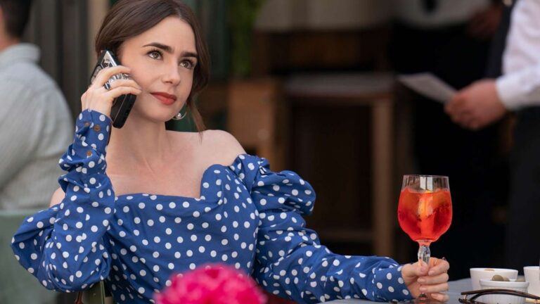 Emily zit op het terras met haar telefoon.