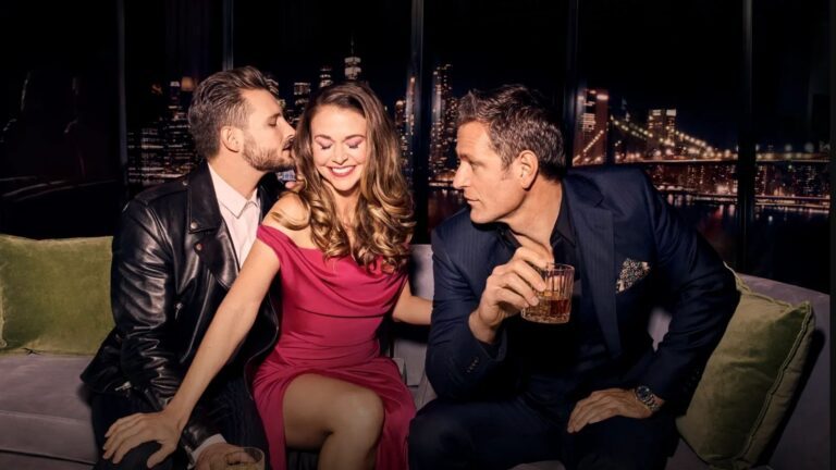 Een vrouw zit tussen twee mannen in. Ze kijken verliefd naar elkaar.