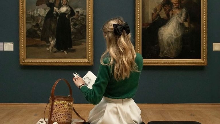 Meisje zit in een museum, ze leest een boek.