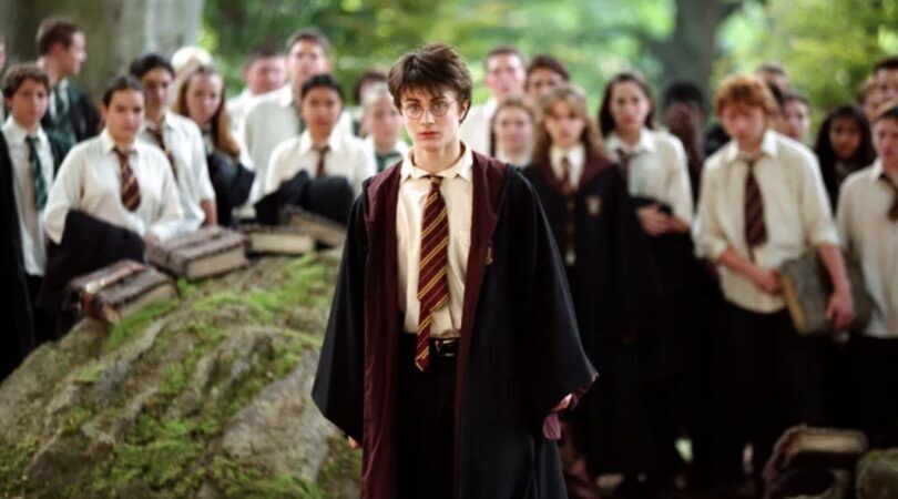 Harry staat in het midden van een groep Hogwarts-studenten.