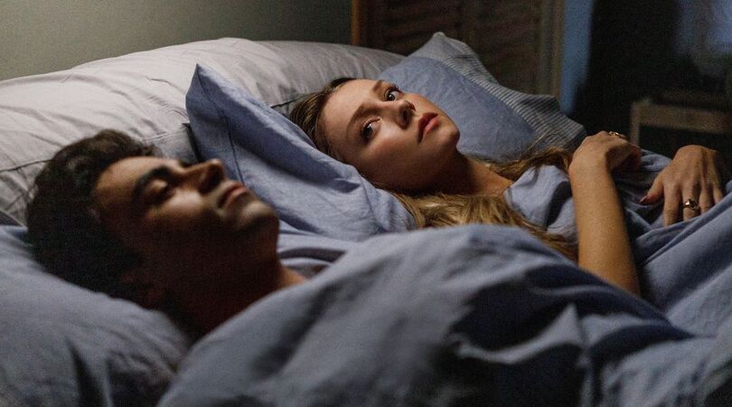 Twee mensen liggen samen in bed.