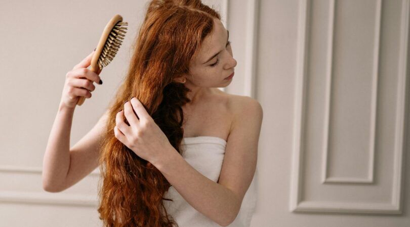 Een vrouw kamt haar haren.