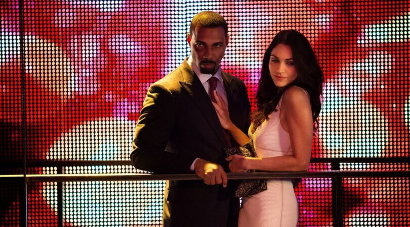 Een man en vrouw kijken neer vanaf een balkon.