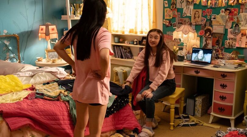 Twee vriendinnen luisteren muziek in een rommelige kamer.