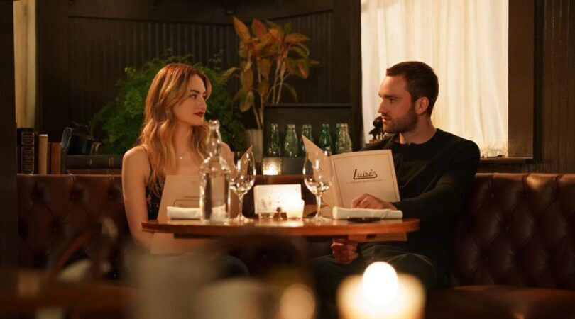 Lucy en Stephen (Tell Me Lies) zitten samen in een restaurant met kaarslicht.