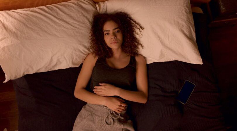 meisje ligt moedeloos op bed