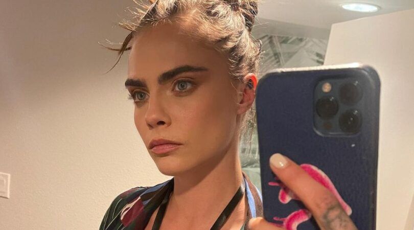 Vrouw met wilde wenkbrauwen neemt een spiegelselfie.