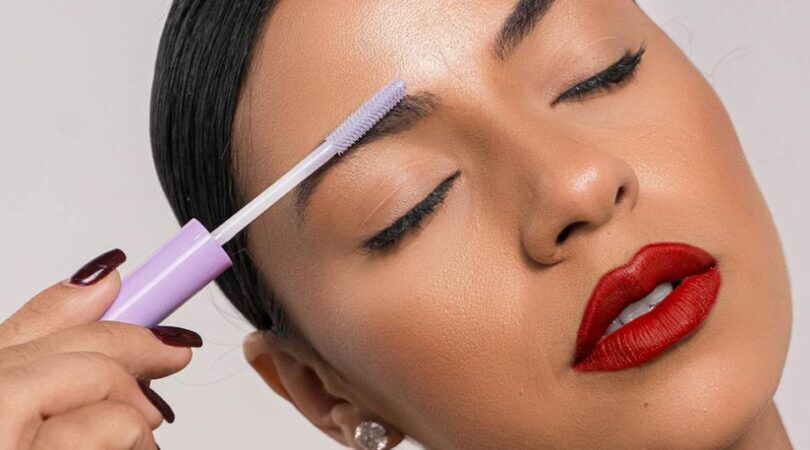 Een vrouw die haar wenkbrauwen met een wenkbrauwgel styled.