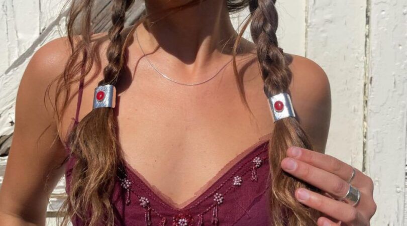 Een vrouw met twee vlechtjes in en haarsieraden als elastiekjes.
