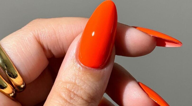 hand met oranje nagellook
