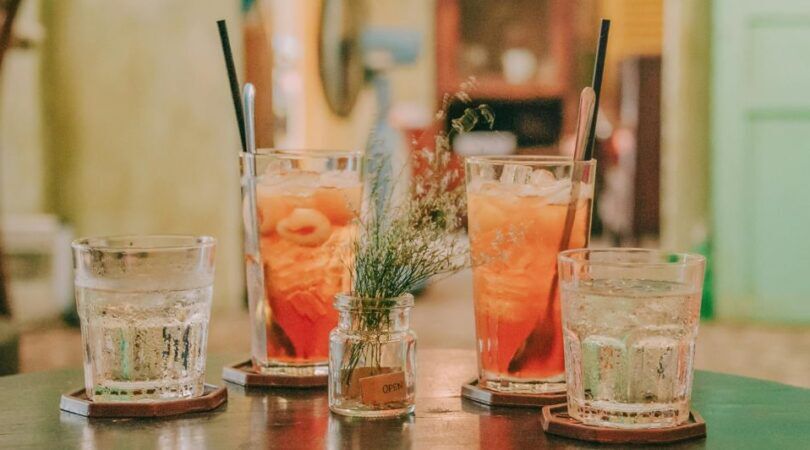 Vier cocktails op een tafel met garnering.