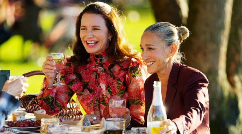 Charlotte en Carrie zitten samen aan tafel te lachen.