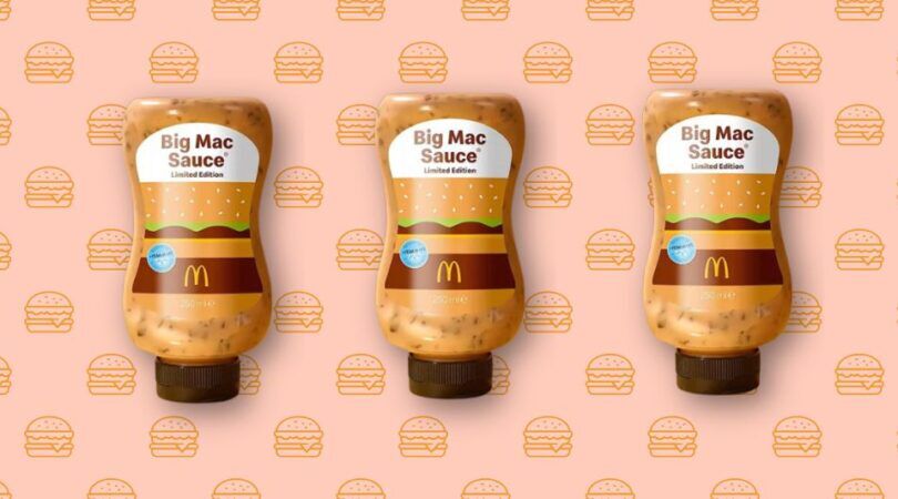 3 Big Mac saus flessen op een rijte op een roze achtergrond.