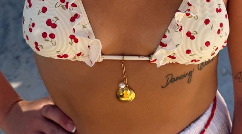 Een vrouw in bikini met een bikini charm aan de bikini.