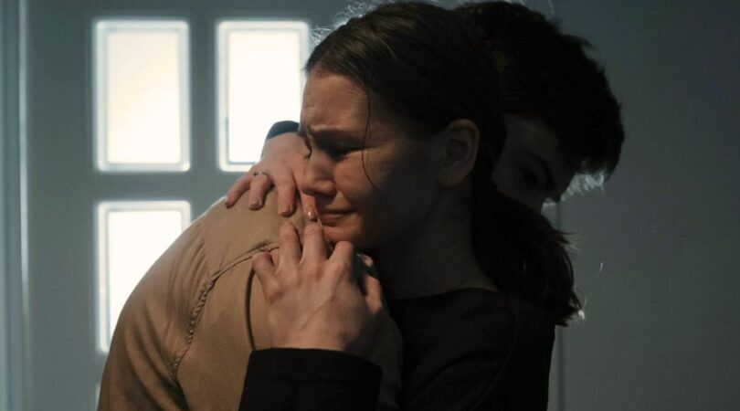 Een vrouw die in een man zijn armen aan het huilen is.