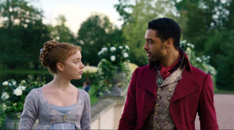 Sc&egrave;ne uit Bridgerton waar Daphne en Simon aan het wandelen zijn en elkaar aankijken.