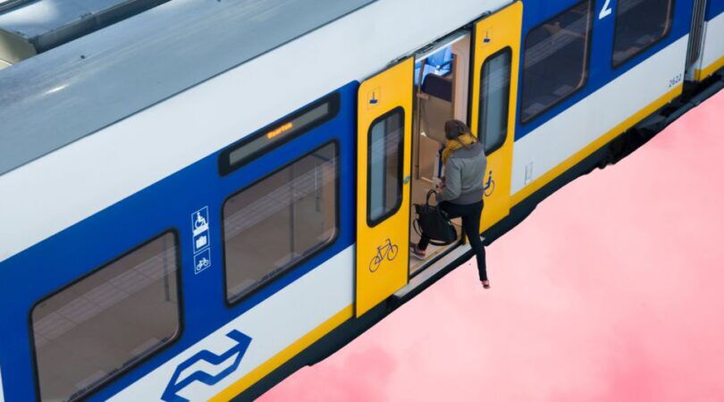 Een vrouw stapt de trein in.