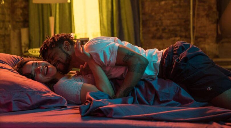 Man en vrouw liggen samen lachend in bed.