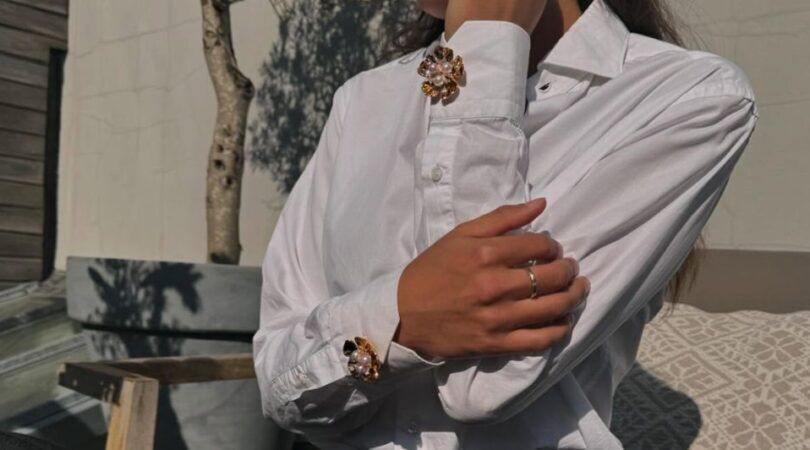 Een vrouw met manchetknopen op haar blouse.