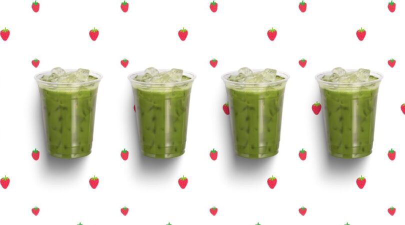 4 iced matcha's op een rijtje, op een aarbeien achtergrond.