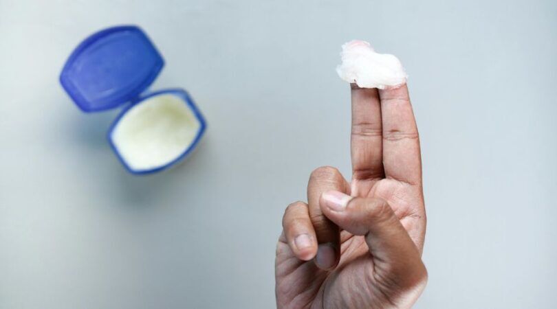 Een hand met een klodder vaseline op de vingers.