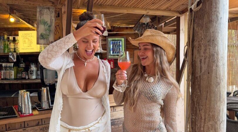 Twee meiden die blij hun drankjes in de lucht houden.