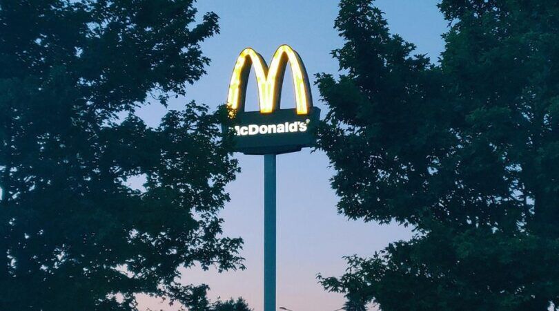 McDonalds logo tussen twee bomen door.