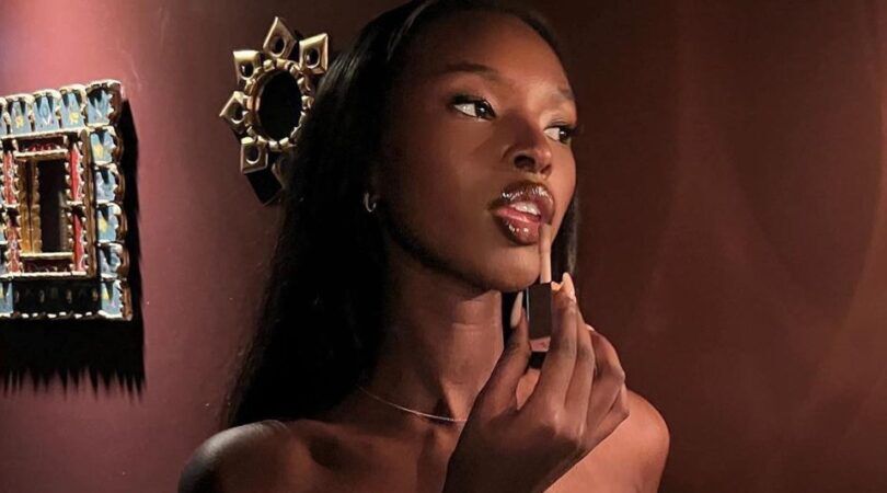 Een vrouw die lipgloss aanbrengt.