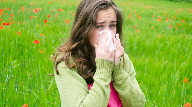 Een meisje niest in een zakdoekje.