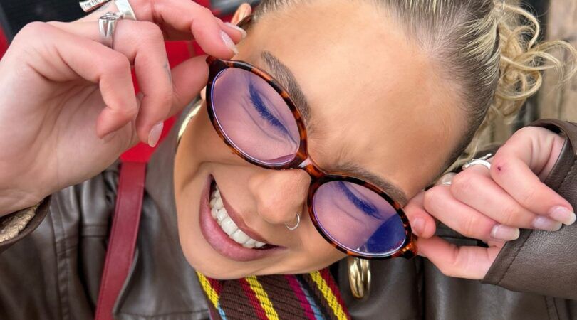 Een jonge vrouw lacht in de camera.