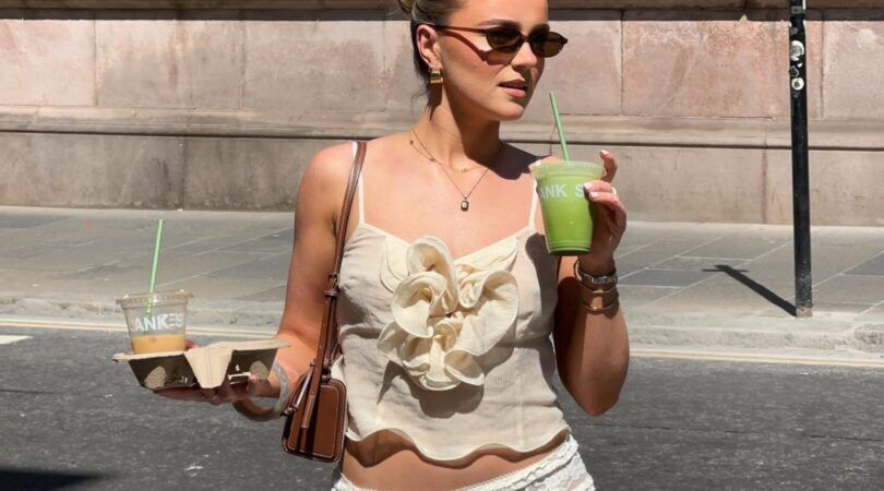 Een jonge vrouw loopt over straat met matcha in haar hand.