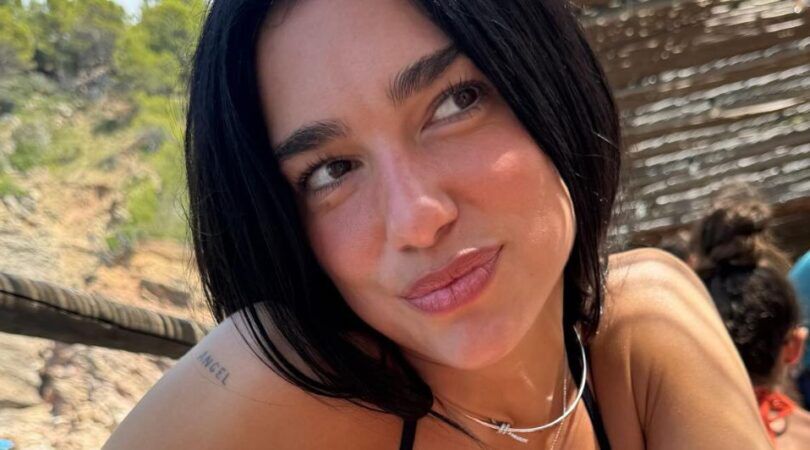 Vrouw kijkt weg van camera op zomers oord.