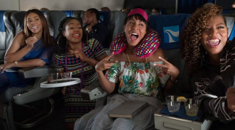 Vier meiden zitten vrolijk in het vloegtuig.
