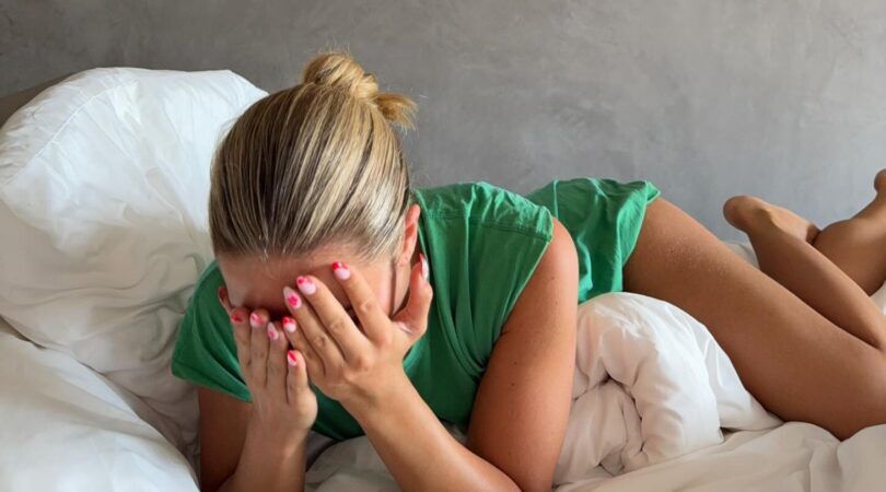 Een meisje ligt in bed in haar pyjama.