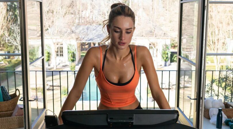 Een vrouw staat in de sportschool.