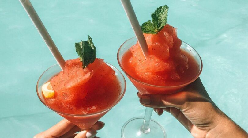 Twee frozen cocktails naast elkaar boven een zwembad.