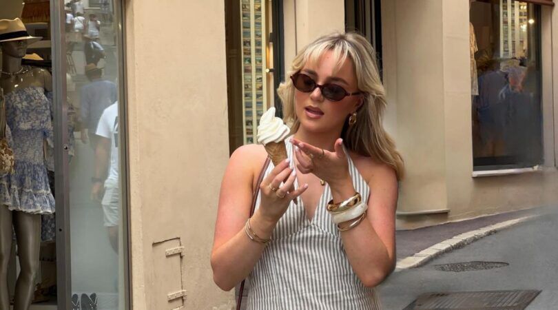 Een jonge vrouw eet een ijsje.