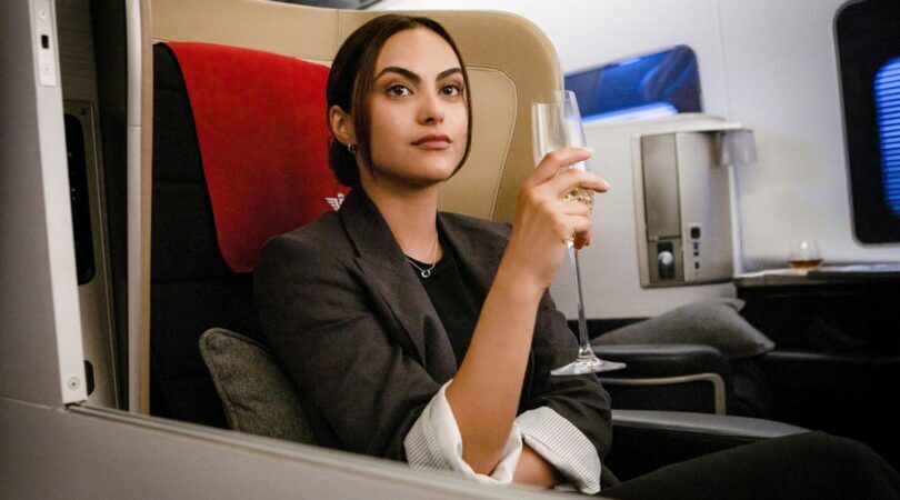 Een jonge vrouw zit in het vliegtuig.