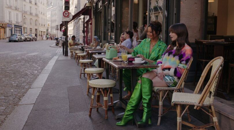 Emily en Mindy zitten op het terras in Parijs.