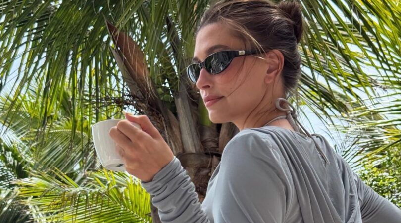 hailey bieber met zonnebril en koffie in haar hand