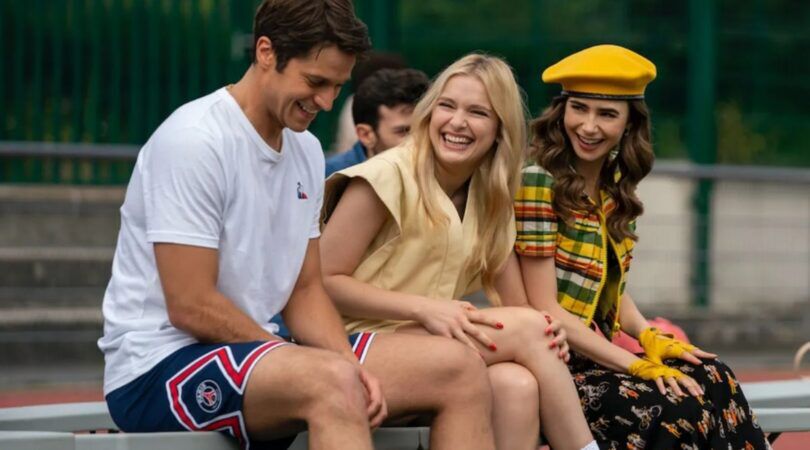 Drie mensen lachen met elkaar.