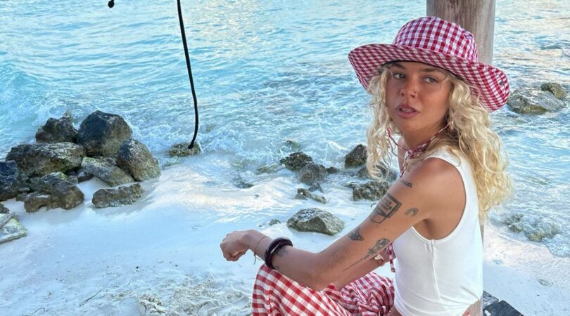 Een meisje is aan het zonnen bij de zee.